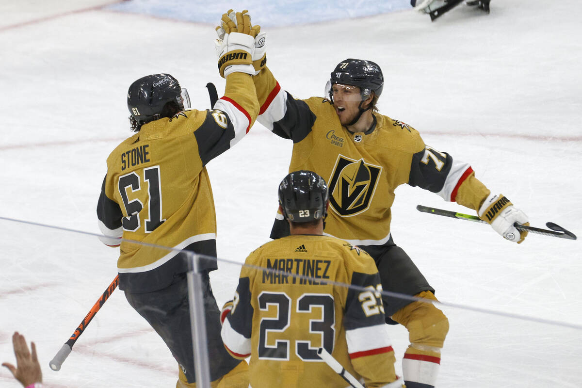 Golden Knights right wing Mark Stone (61) receives a high-five from Golden Knights center Willi ...