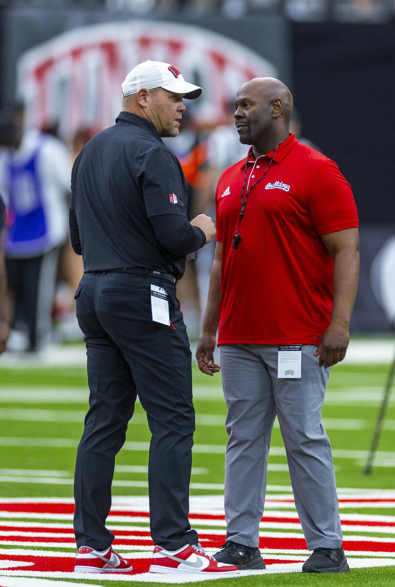 UNLV Head Coach Barry Odom talks with Fresno State Head Coach Tim Skipper during warm ups of th ...