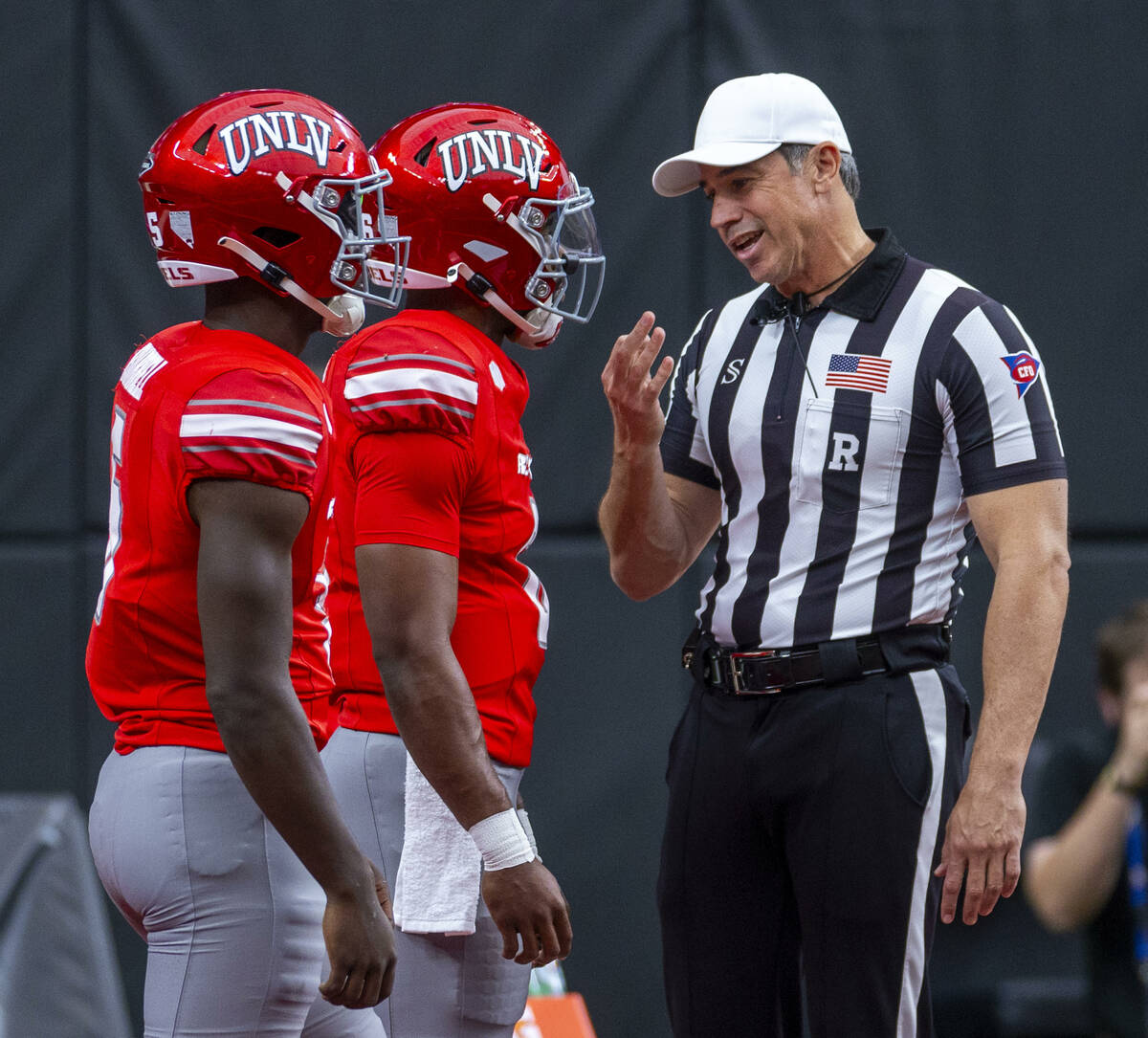 UNLV quarterback Hajj-Malik Williams (6), center, with running back Greg Burrell (5) talks with ...