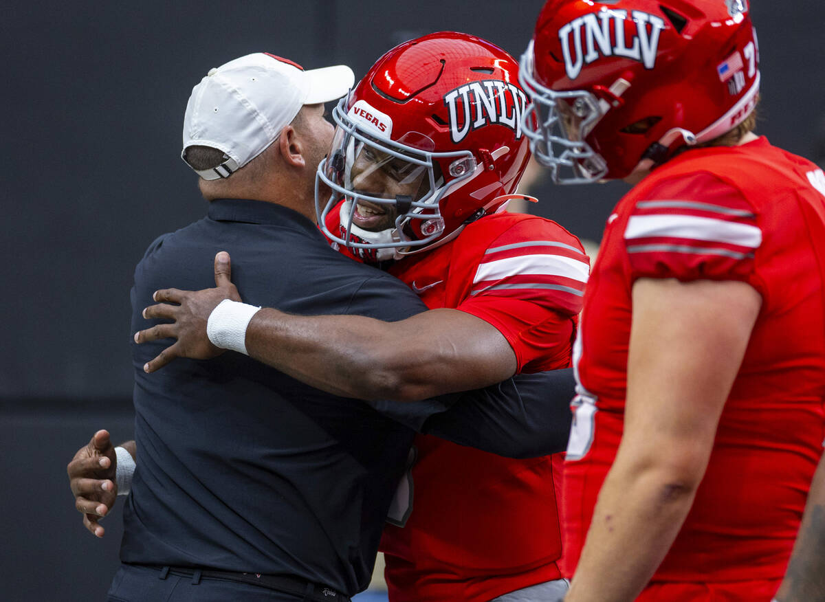 UNLV Head Coach Barry Odom hugs quarterback Hajj-Malik Williams (6) during warm ups of their NC ...