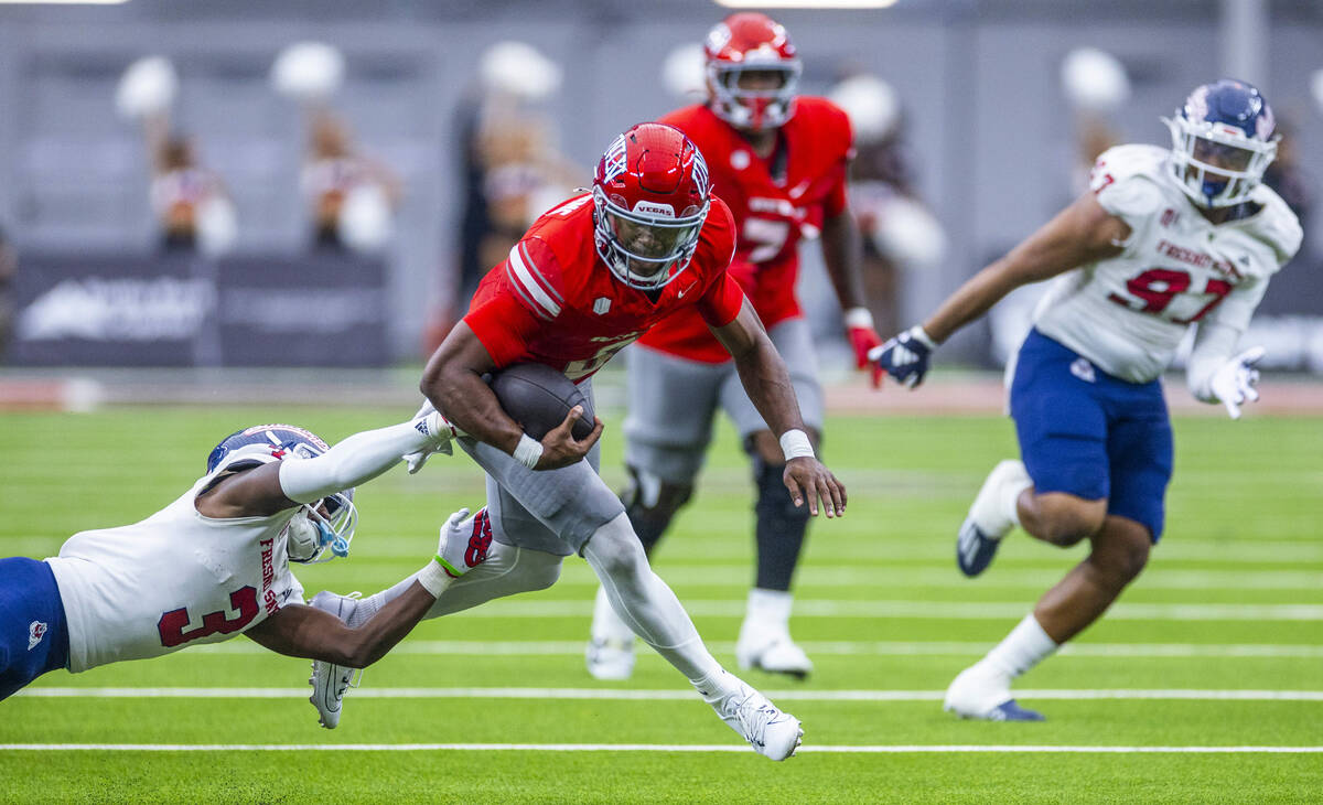 UNLV quarterback Hajj-Malik Williams (6) is grabbed from behind by Fresno State Bulldogs defens ...