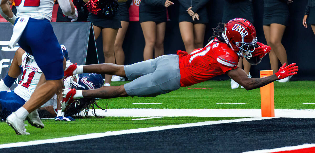 UNLV wide receiver Ricky White III (11) dives for a touchdown out of the arms of Fresno State B ...