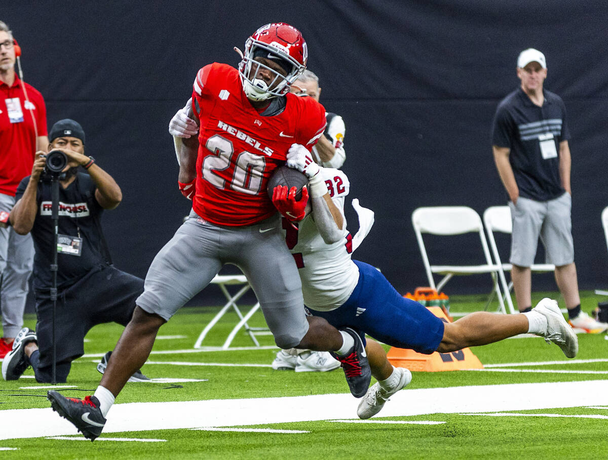 UNLV running back Kylin James (20) drags Fresno State Bulldogs defensive back Dean Clark (32) t ...