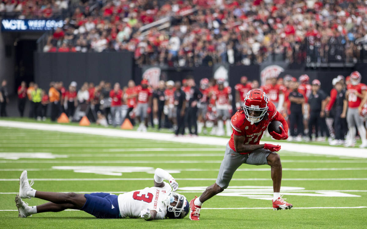 UNLV wide receiver Ricky White III (11) avoids Fresno State defensive back Al'zillion Hamilton ...