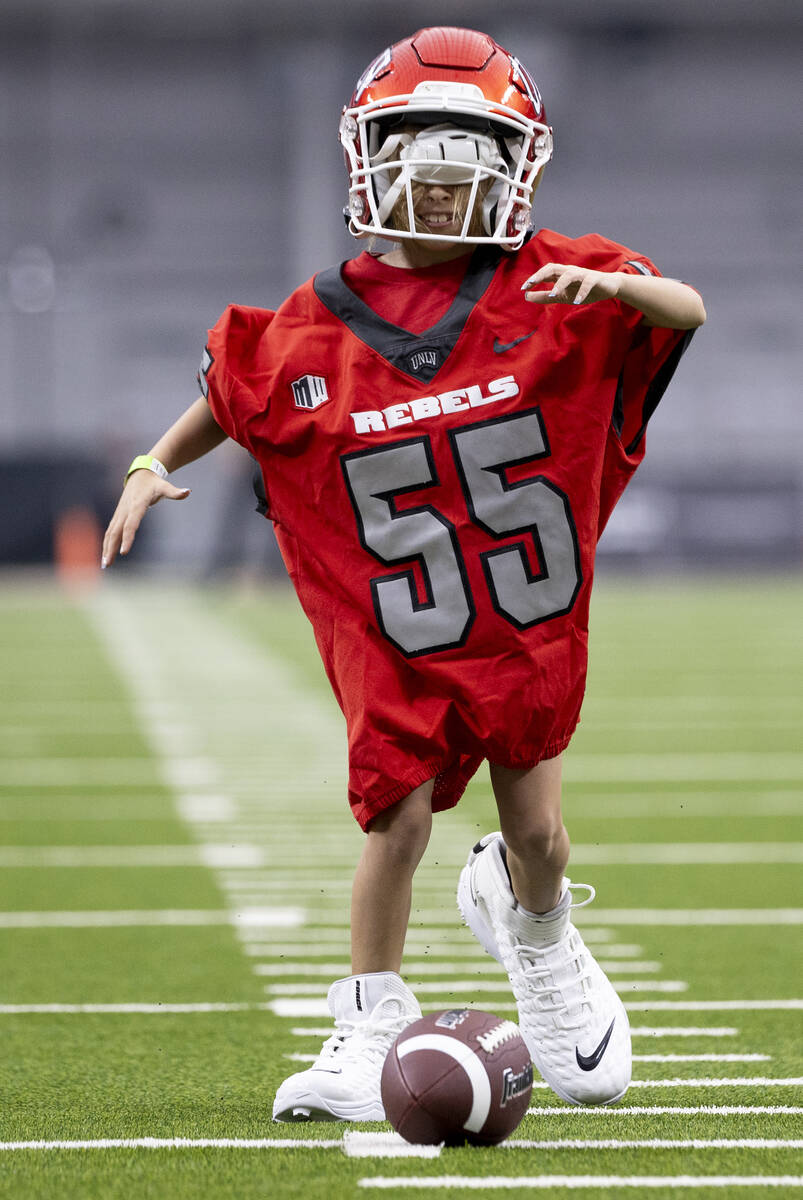 A young UNLV fan attempts to score a touchdown with oversized equipment during the college foot ...