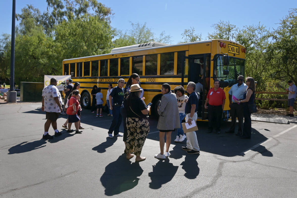 Clark County School District trustee Brenda Zamora, center, talks with community members as Chi ...