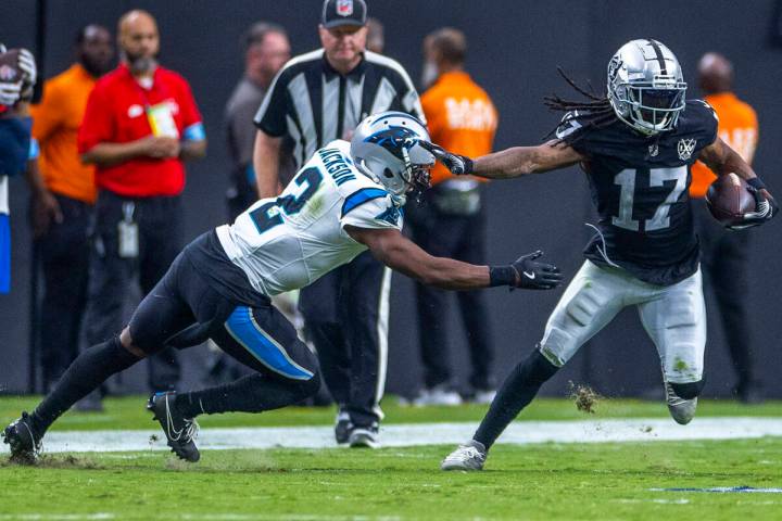 Raiders wide receiver Davante Adams (17) evades a tackle attempt by Carolina Panthers cornerbac ...