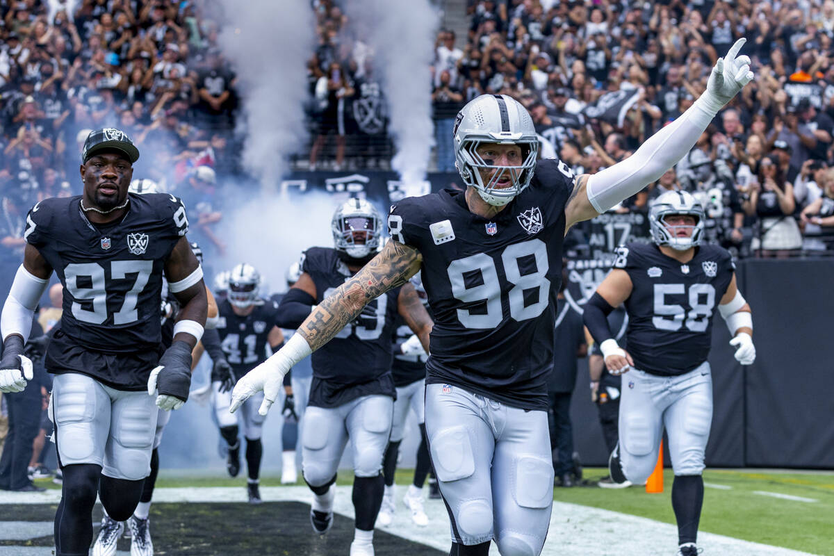 Raiders defensive end Maxx Crosby (98) leads his teammates onto the field before the first half ...