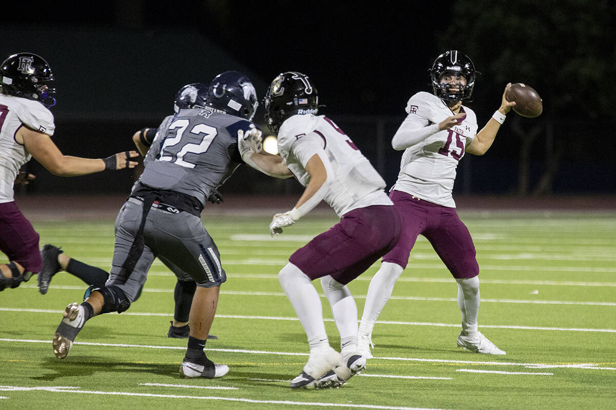 Faith Lutheran senior Alexander Rogers (15) looks to throw the ball during the high school foot ...