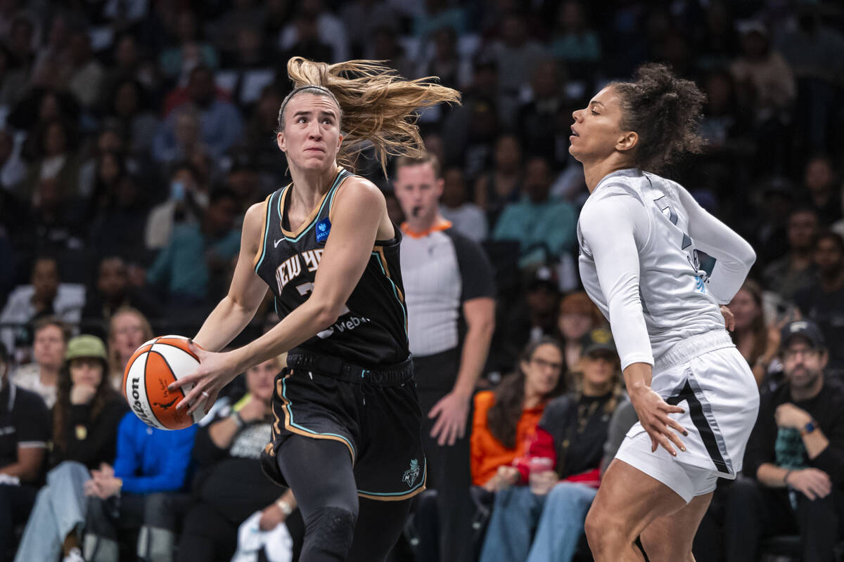 New York Liberty guard Sabrina Ionescu, left, is defended by Las Vegas Aces forward Alysha Clar ...