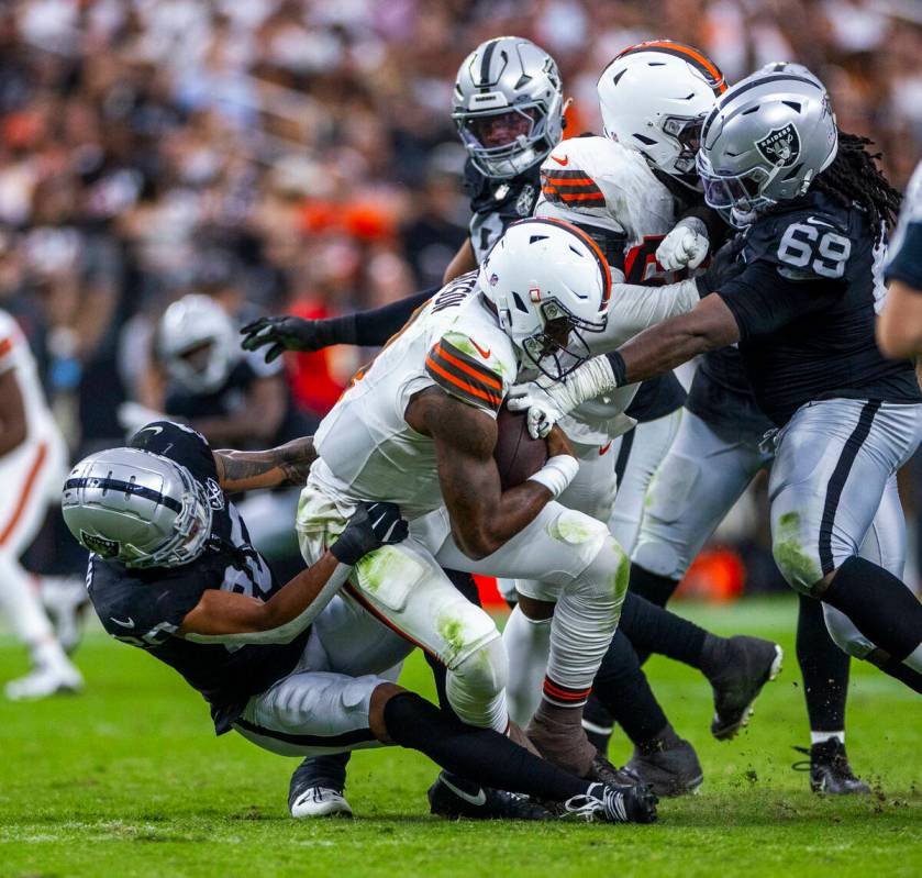 Raiders safety Isaiah Pola-Mao (20) and defensive tackle Adam Butler (69) team up to sack Cleve ...