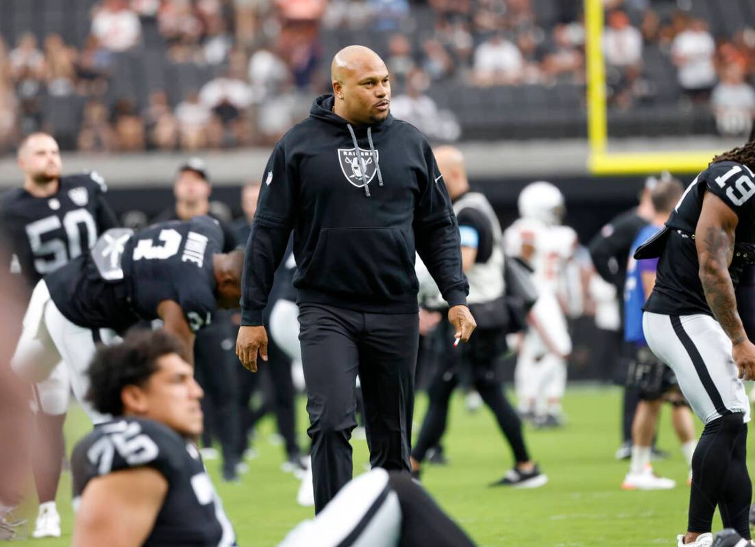 Raiders head coach watches his team warm up before an NFL game against the Cleveland Browns at ...