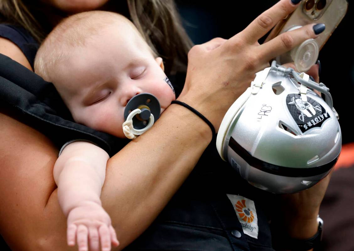 Five-month-old Josiah Brogdon takes a nap on his mother's arm during an NFL game between Raider ...