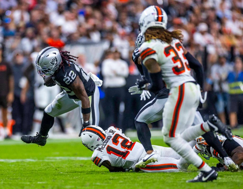 Raiders running back Alexander Mattison (22) breaks a tackle attempt by Cleveland Browns safety ...