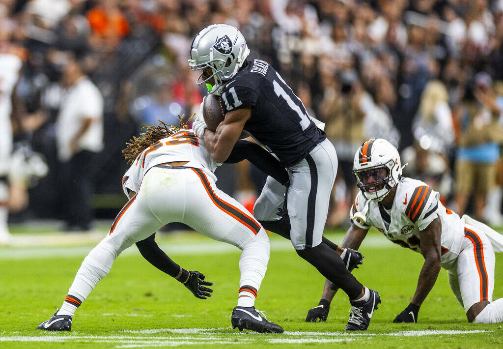 Raiders wide receiver Tre Tucker (11) looks to break a tackle by Cleveland Browns safety Ronnie ...