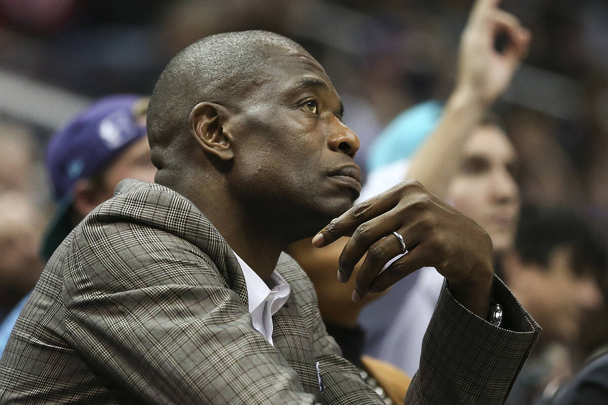 Former NBA player Dikembe Mutombo sits court side in the second half of an NBA basketball game ...