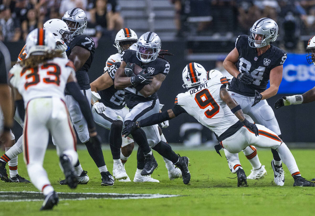 Raiders running back Alexander Mattison (22) blasts through the line past Cleveland Browns safe ...