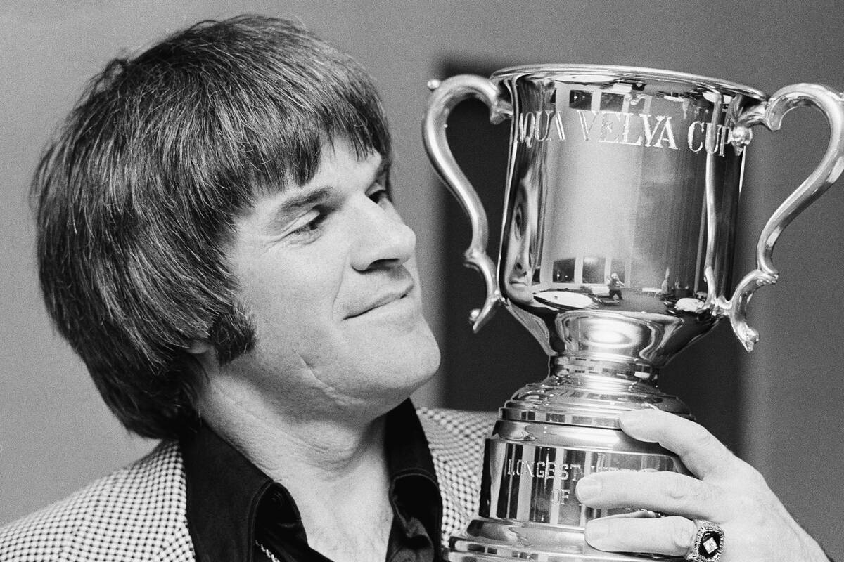 Philadelphia Phillies star Pete Rose admires the new Aqua Velva cup for consecutive hitting str ...