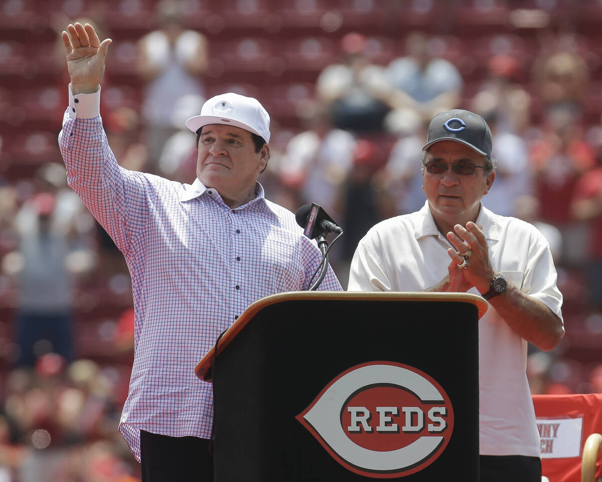 Former Cincinnati Reds player Pete Rose, left, waves to the crowd alongside Reds Johnny Bench, ...