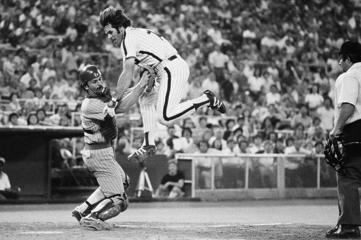 Pete Rose of the Philadelphia Phillies, right, flies through the air in an attempt to score a r ...