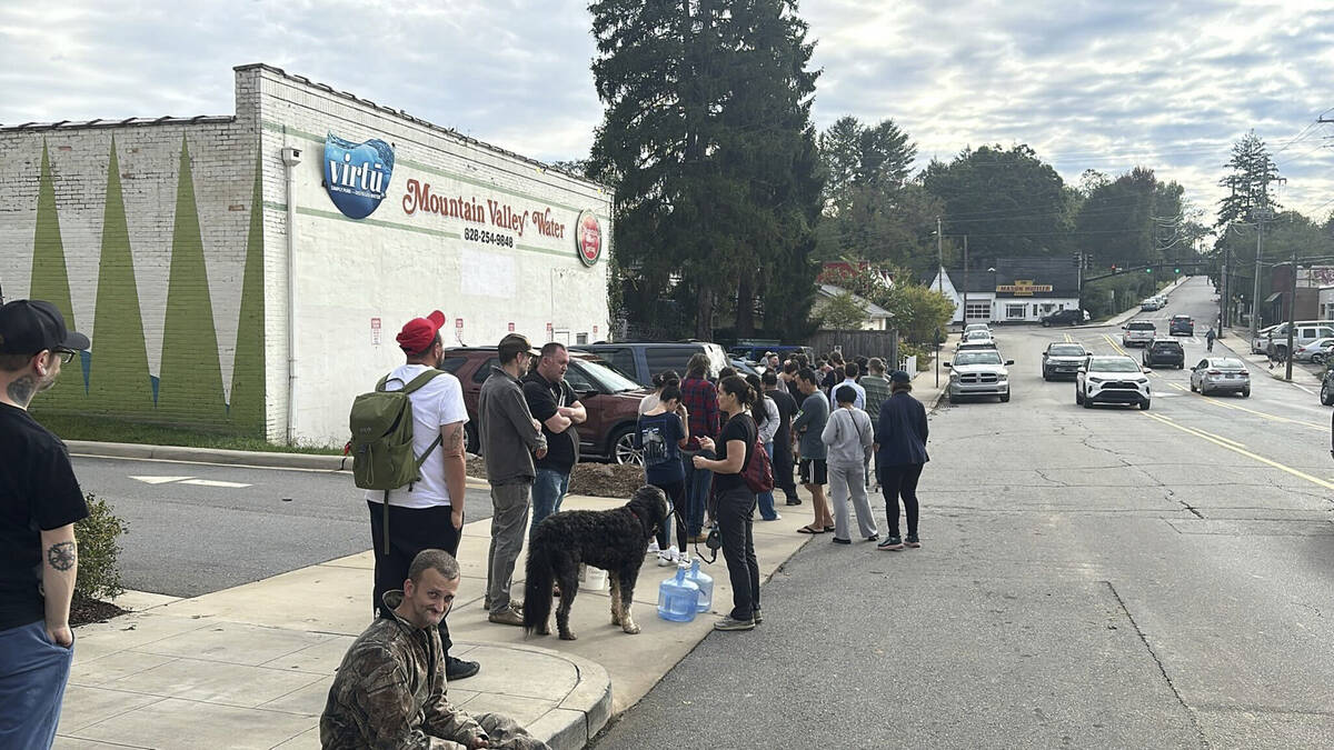 People wait to gather water at Mountain Valley Water in the aftermath of Hurricane Helene in We ...