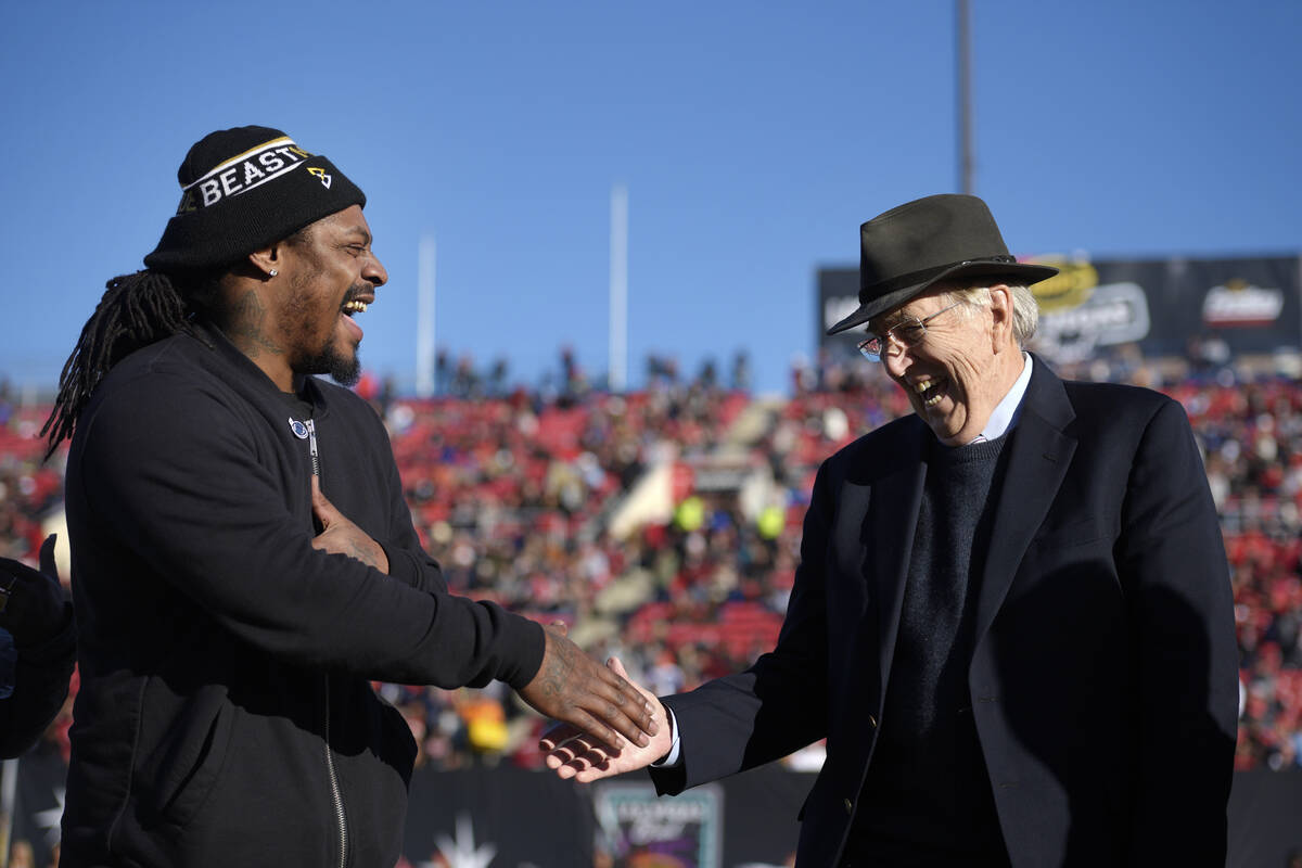 Former NFL star Marshawn Lynch and broadcaster Brent Musburger shake hands while being honored ...