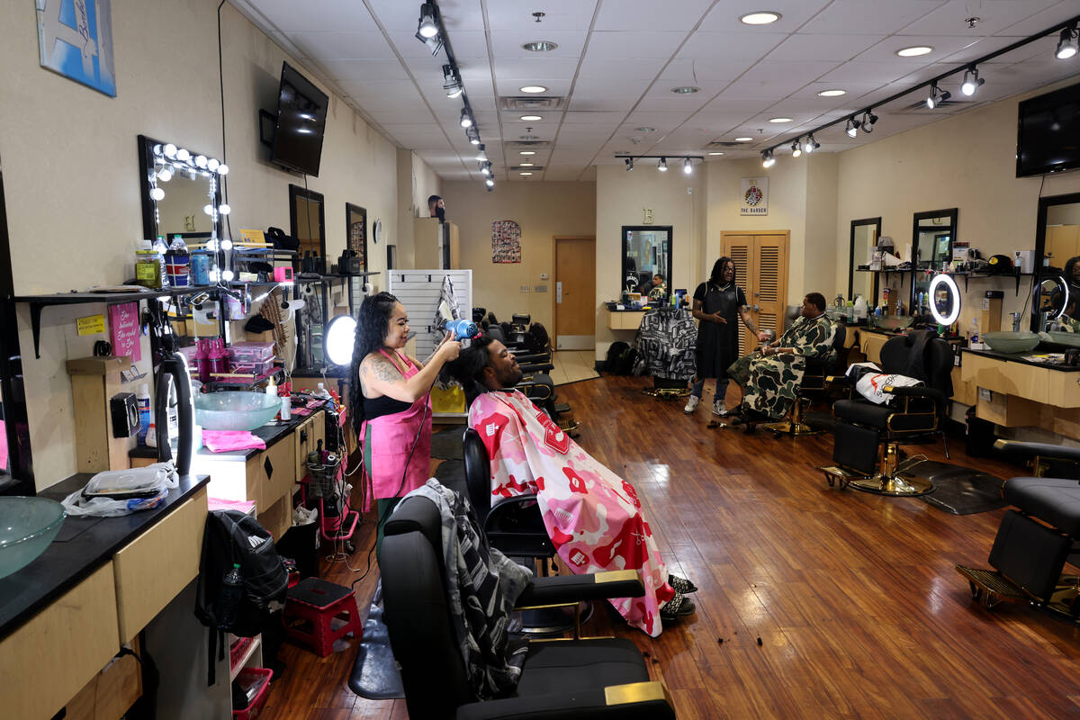 Leesah Khammany, a barber at A1 Barbershop, works with a client at the Boulevard Mall on Maryla ...