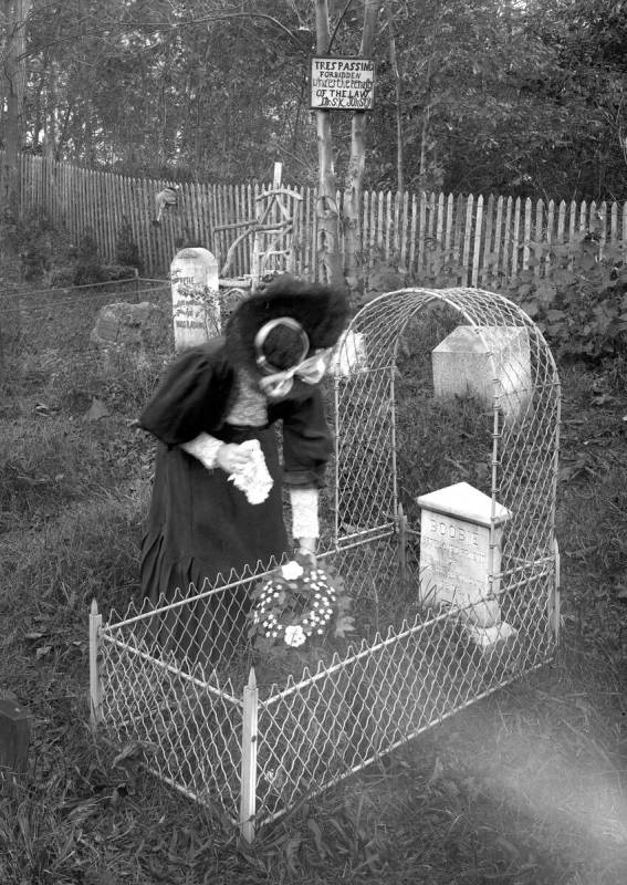 A woman leaves flowers at a grave at Hartsdale pet cemetery in New York circa 1905. (Courtesy o ...