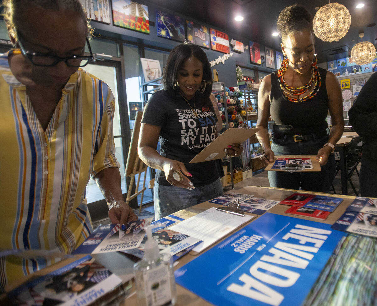 Shaunda Necole, center, grabs supplies during a canvassing and phone banking event for the Demo ...