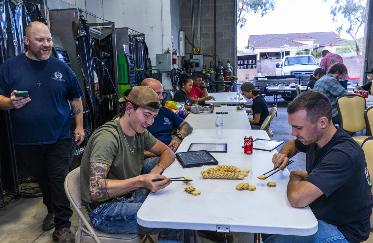 Founder Greg Gilbert, left, times particpants in a cookie stacking contest using chop sticks du ...