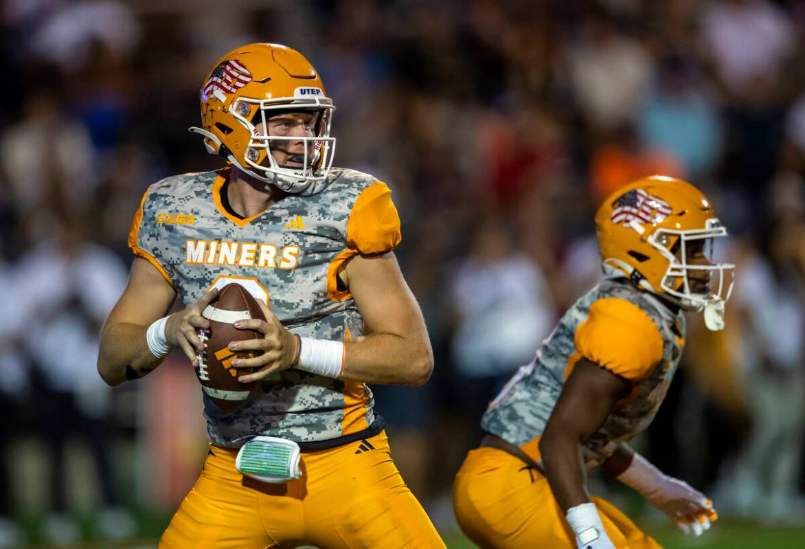 UTEP quarterback Gavin Hardison, left, looks to throw a pass during the first half of an NCAA c ...