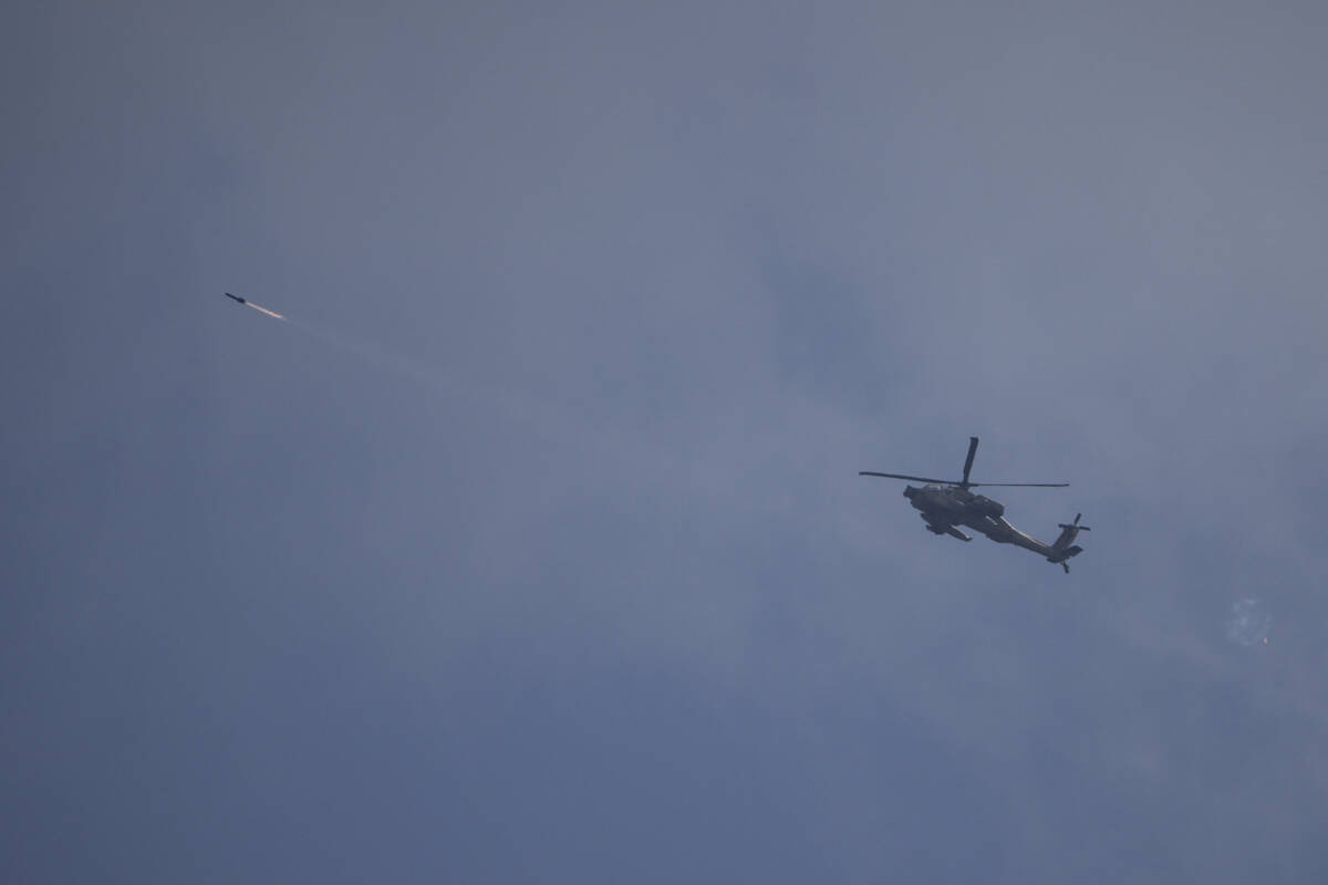 An Israeli Apache helicopter fires a missile towards southern Lebanon as seen from northern Isr ...