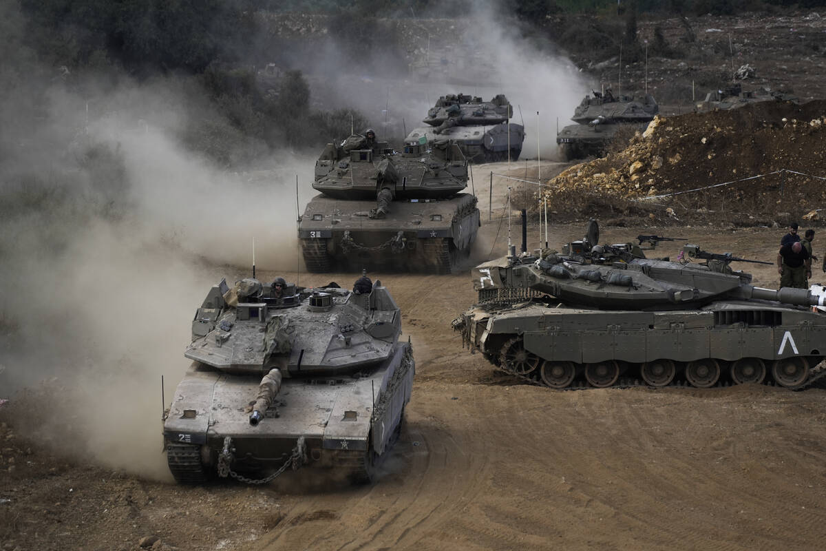 Israeli army tanks maneuver in a staging area in northern Israel near the Israel-Lebanon border ...