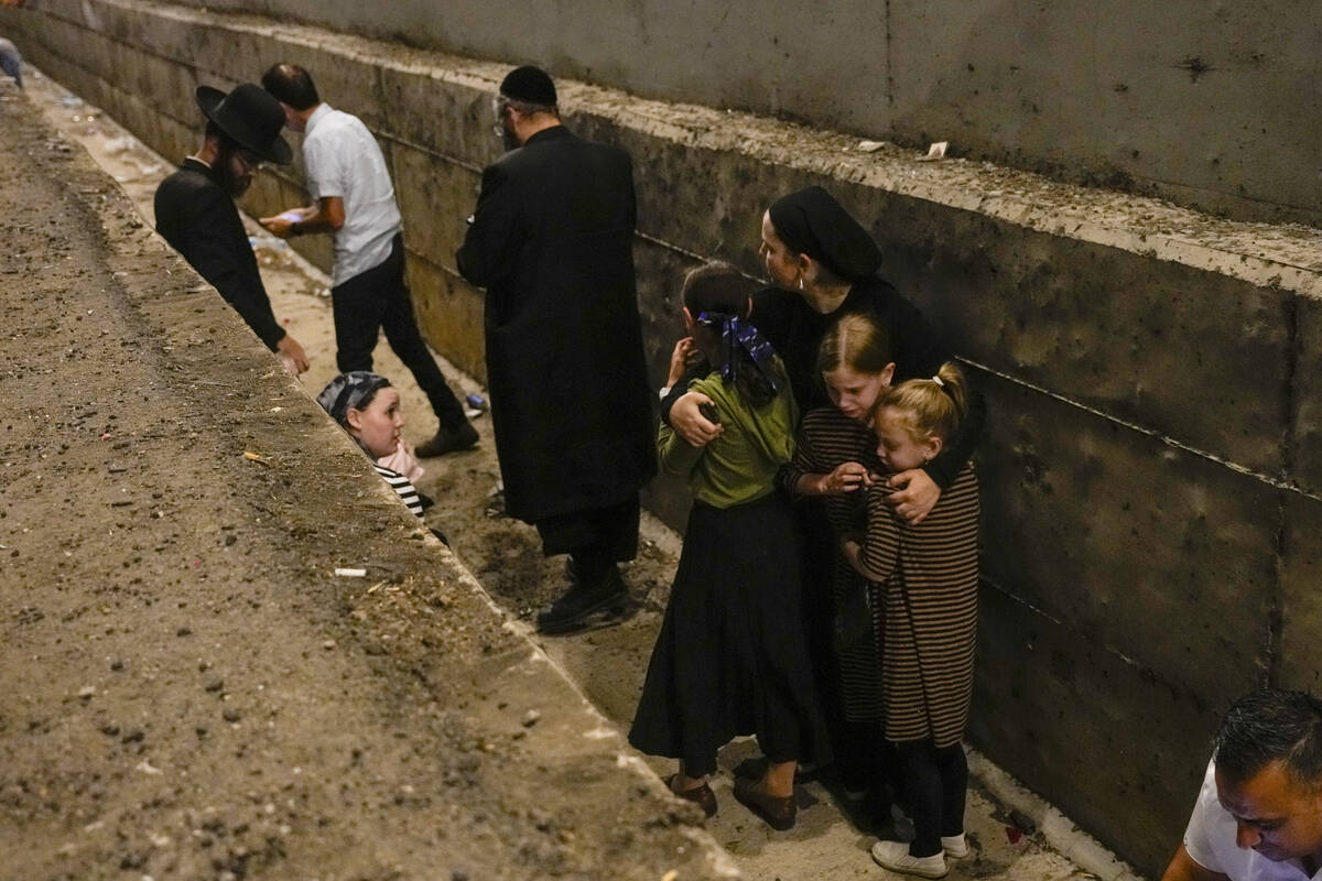 People take cover on the side of the road as a siren sounds a warning of incoming missiles fire ...