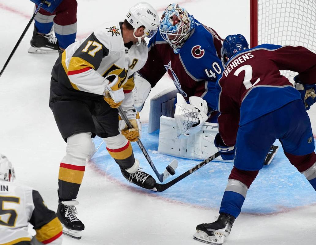 Vegas Golden Knights defenseman Ben Hutton, left, takes a shot as Colorado Avalanche goaltender ...