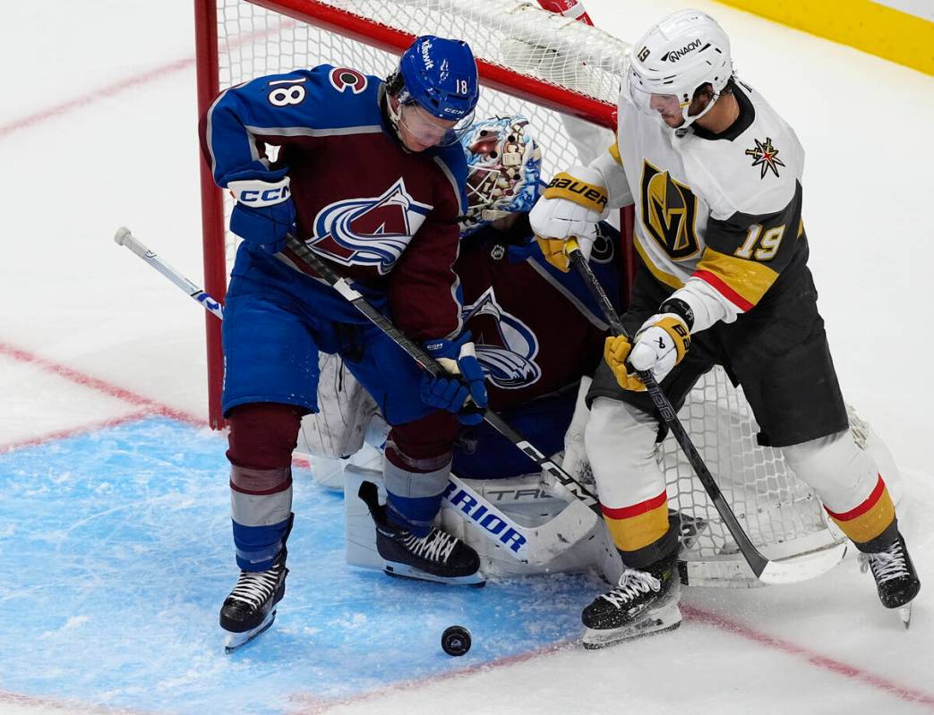 Colorado Avalanche defenseman Jack Ahcan, front left, tries to clear the puck from in front of ...