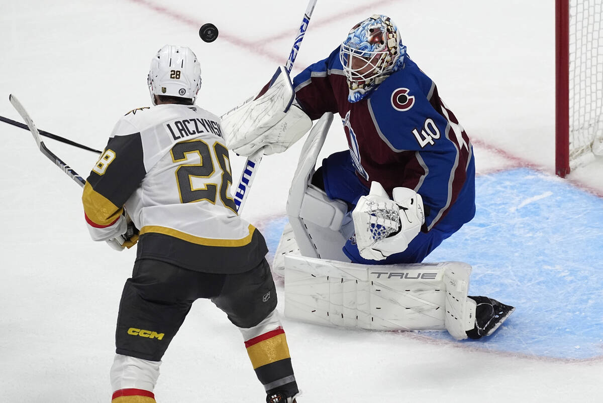 Vegas Golden Knights center Tanner Laczynski, left, knocks the puck past Colorado Avalanche goa ...