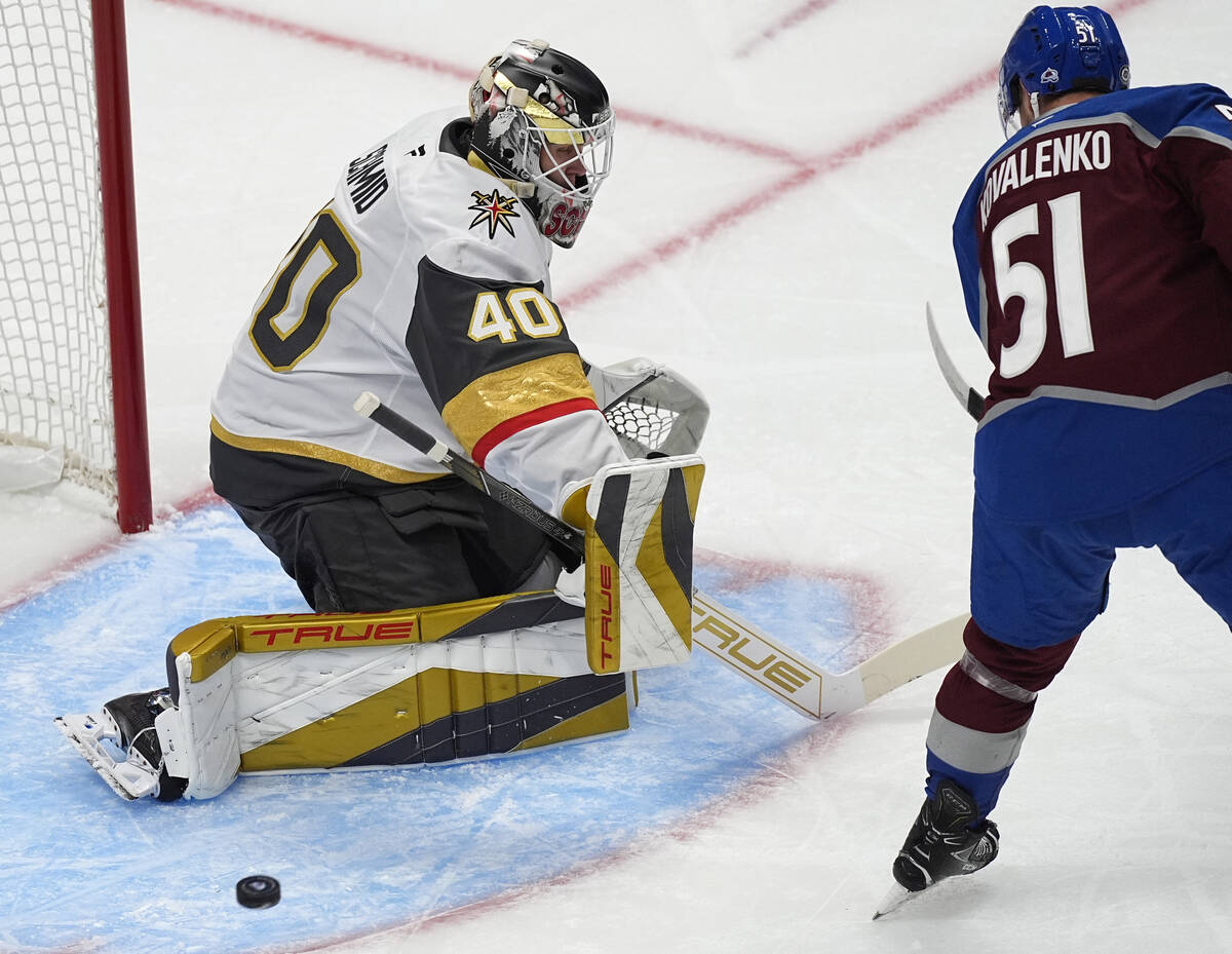 Vegas Golden Knights goalie Akira Schmid, left, deflects a shot by Colorado Avalanche right win ...