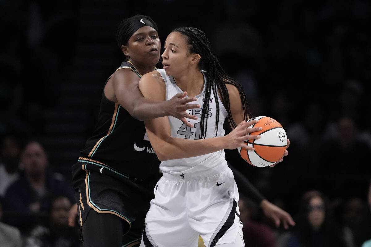 New York Liberty's Jonquel Jones, left, defends Las Vegas Aces' Kiah Stokes during the first ha ...