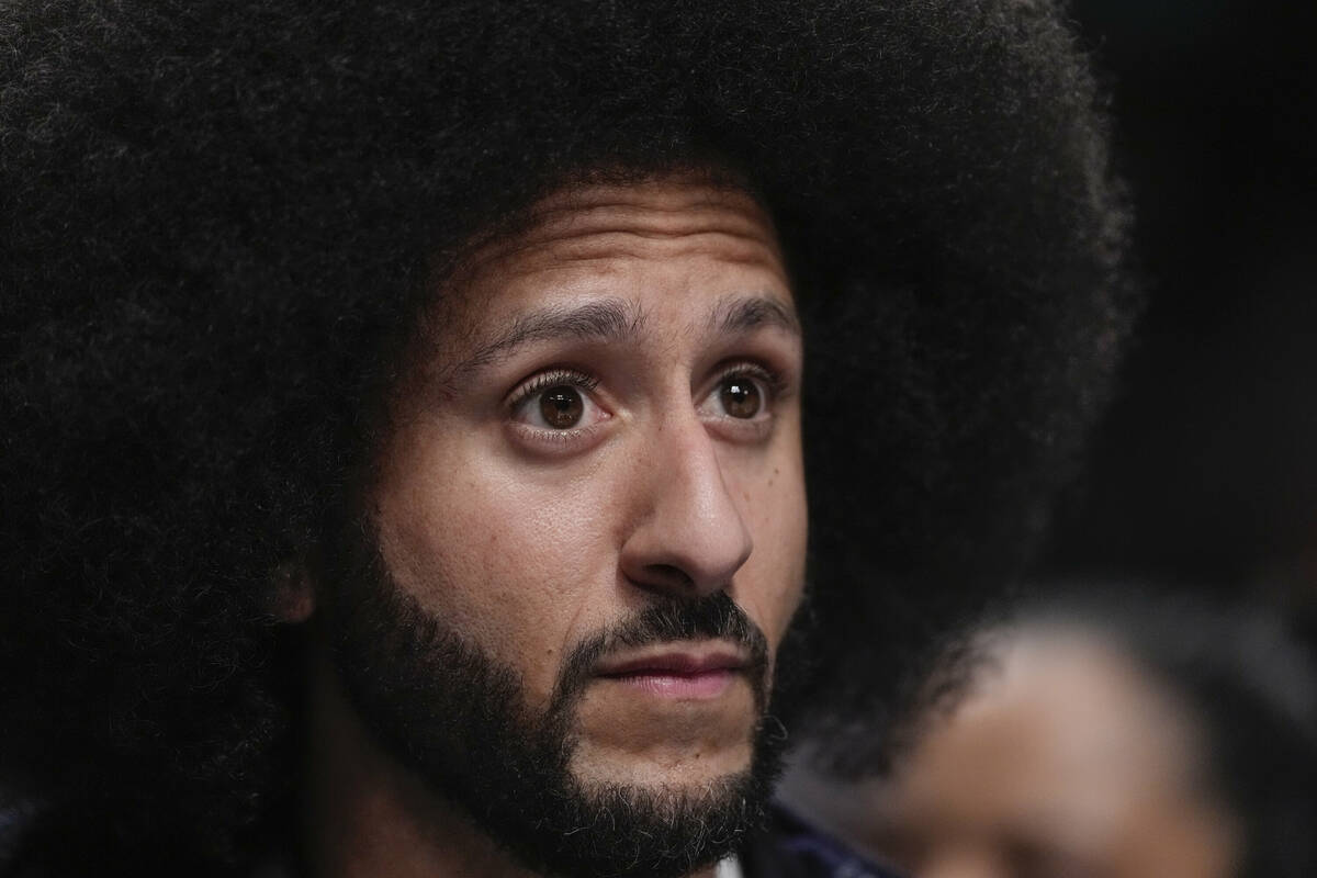 Colin Kaepernick watches during the second half of a WNBA basketball semifinal game between the ...