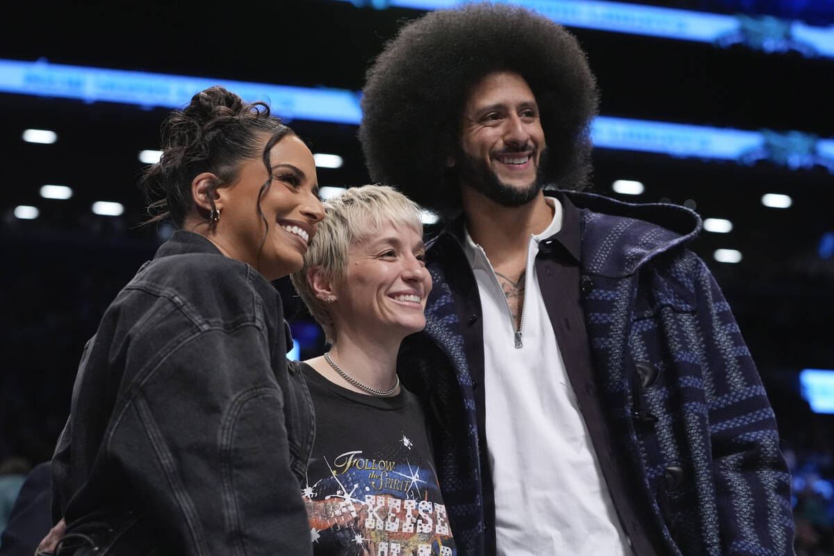 Megan Rapinoe, center, Colin Kaepernick, right, and Nessa Diab, left, pose for photographs duri ...