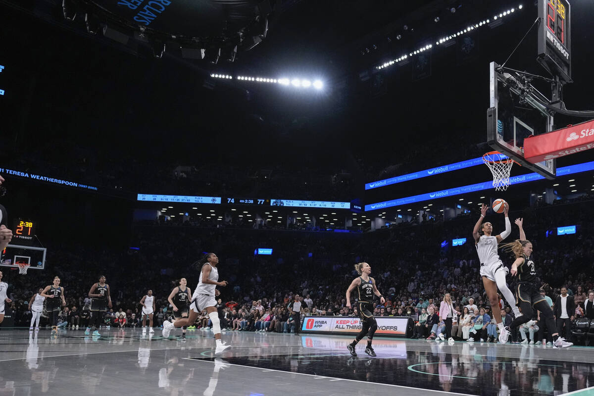 Las Vegas Aces' A'ja Wilson (22) drives past New York Liberty's Sabrina Ionescu (20) during the ...