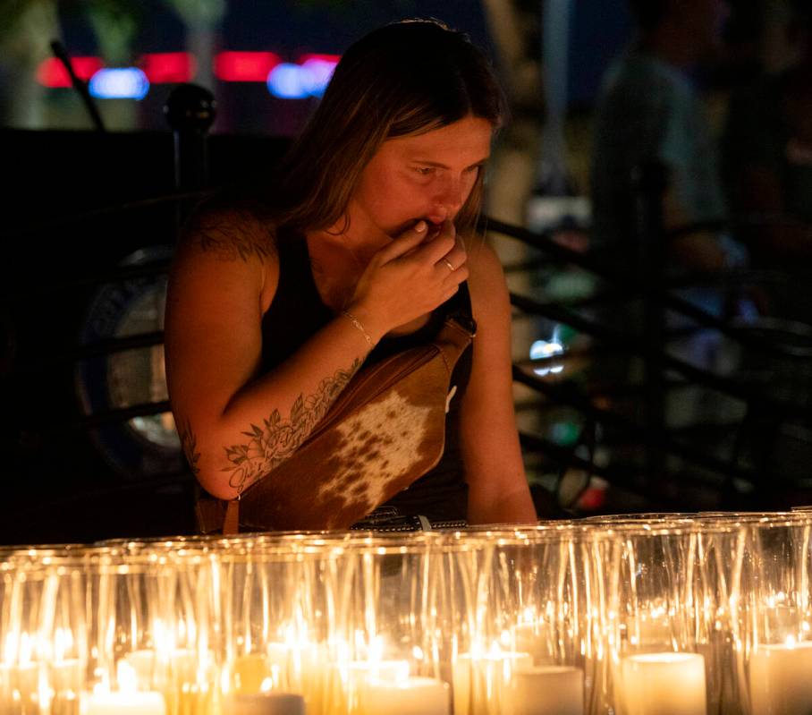 Mourners look for the candle lit for their loved ones after the candlelight vigil to remember t ...