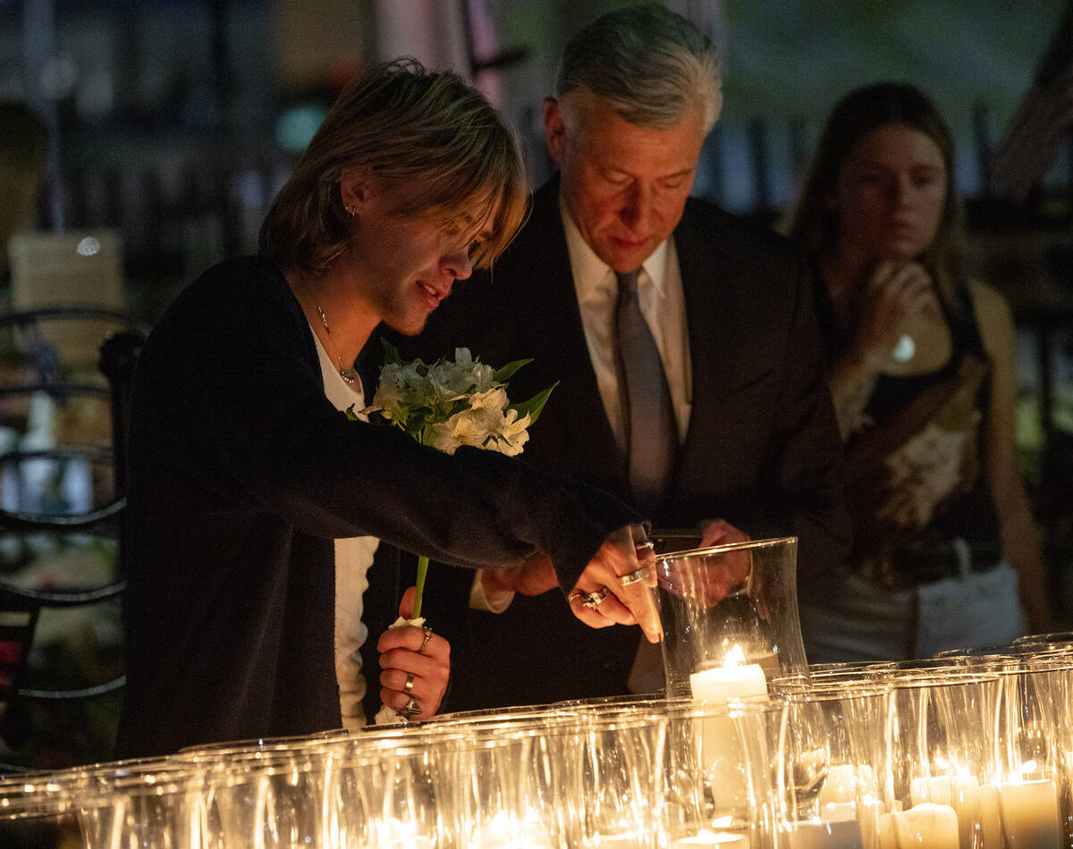 Mourners pick out the candle lit for their loved ones after the candlelight vigil to remember t ...