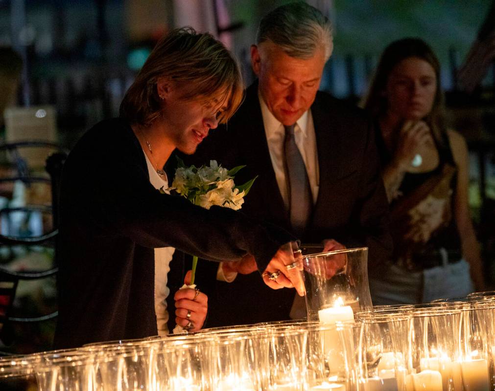 Mourners pick out the candle lit for their loved ones after the candlelight vigil to remember t ...