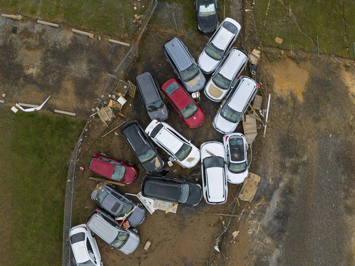 Vehicles and debris that were caught in a flash flood from Hurricane Helene rest on the side of ...