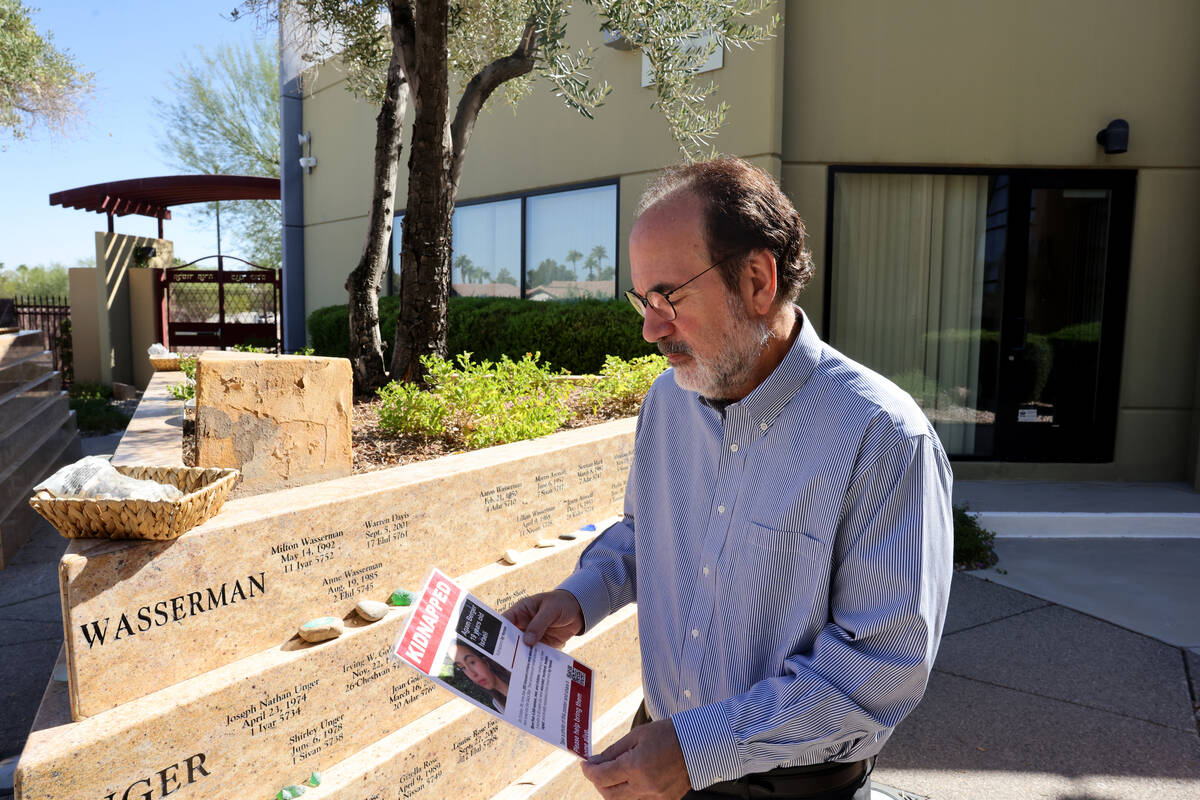 Rabbi Sanford Akselrad of Congregation Ner Tamid in Henderson shows a hostage poster ahead of t ...