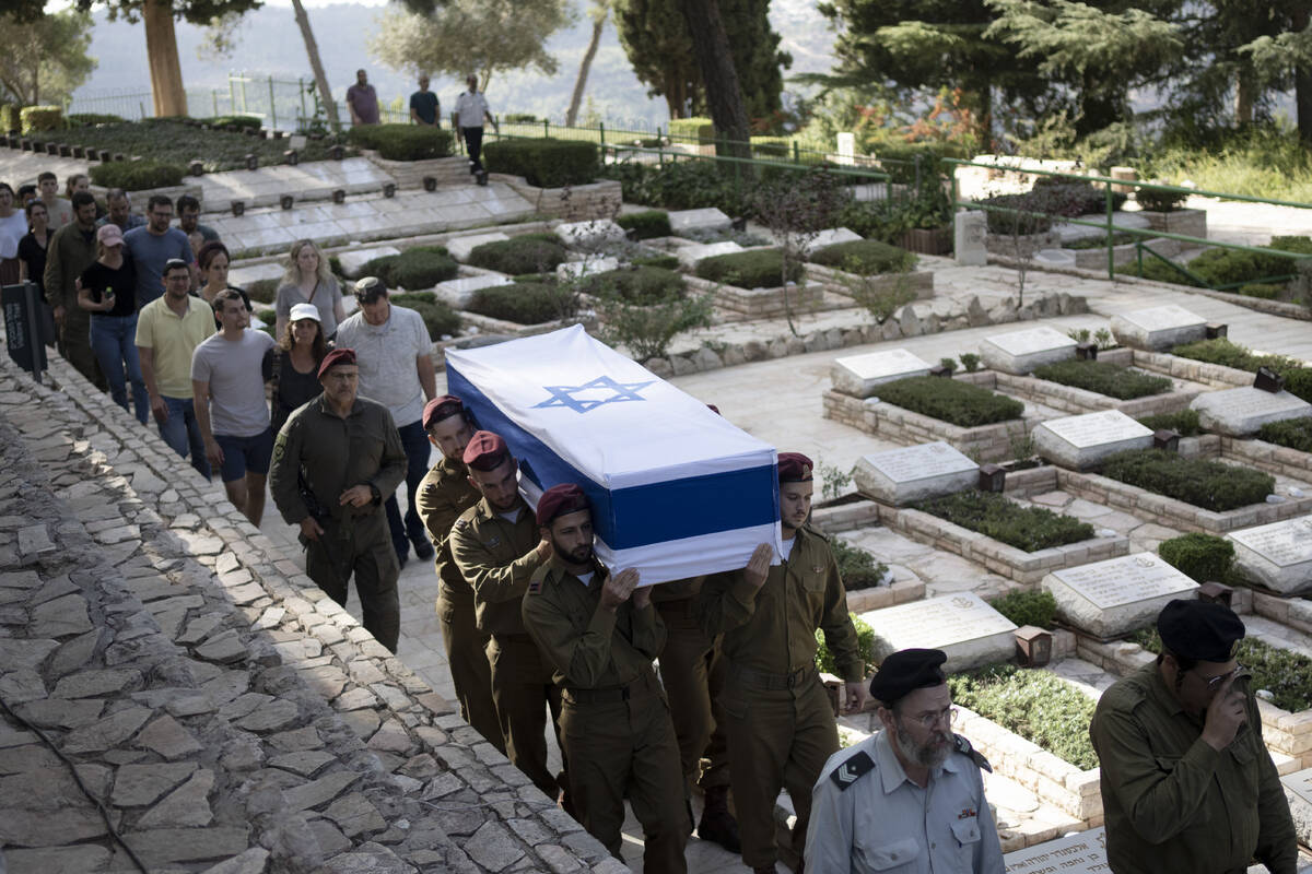 Soldiers carry the coffin of Israeli Army Capt. Eitan Yitzhak Oster, who was killed in action i ...