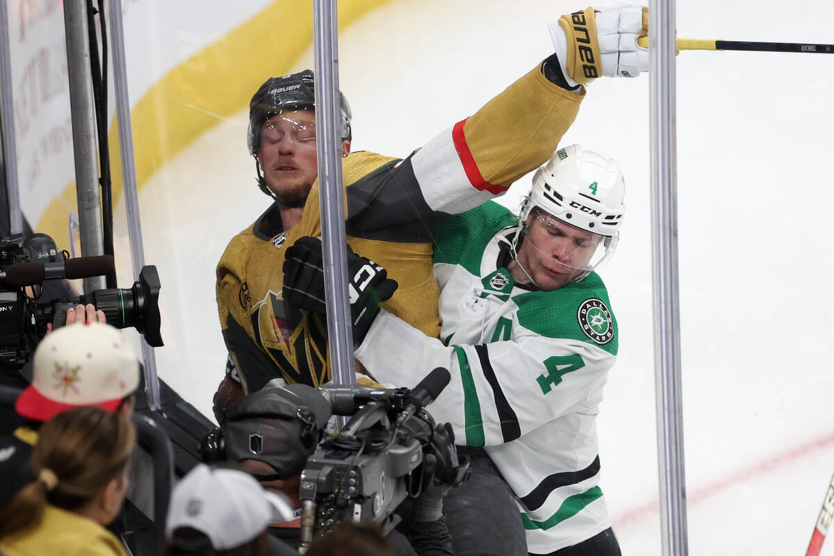 Stars defenseman Miro Heiskanen (4) slams Golden Knights center Jack Eichel (9) into the boards ...