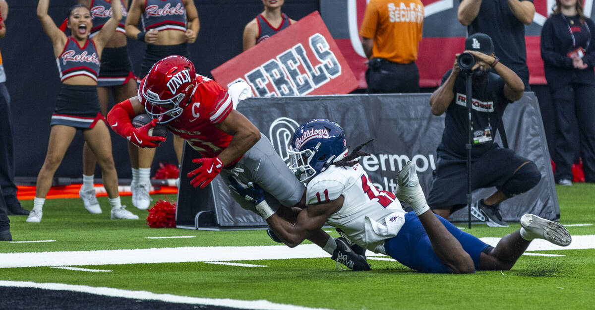 UNLV wide receiver Jacob De Jesus (21) extends for a scoring attempt over Fresno State Bulldogs ...